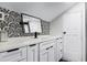 Modern bathroom features sleek black hardware, decorative wallpaper, and ample counter space at 1017 Florida Ave, St Cloud, FL 34769
