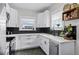 Modern kitchen with white cabinets, black backsplash, and stainless steel appliances at 1017 Florida Ave, St Cloud, FL 34769