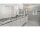 Modern bathroom featuring a double vanity with granite countertop and glass-enclosed shower at 2009 Tropical Palms Cir, Kissimmee, FL 34747