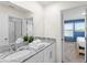 Bathroom with double sinks and a granite countertop, adjacent to a bedroom with natural light and a window at 2009 Tropical Palms Cir, Kissimmee, FL 34747
