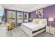 Stylish bedroom featuring a queen-sized bed, abundant natural light, and purple walls at 2009 Tropical Palms Cir, Kissimmee, FL 34747