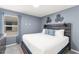 Bedroom with a blue accent wall, decorative wall art, a plush white bed, and a window with blinds at 2009 Tropical Palms Cir, Kissimmee, FL 34747