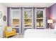Bright bedroom with large windows, a yellow accent chair, and tranquil views of the outdoors at 2009 Tropical Palms Cir, Kissimmee, FL 34747