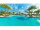 Inviting community pool area with clear blue water, surrounding lounge chairs, and tropical palm trees at 2009 Tropical Palms Cir, Kissimmee, FL 34747