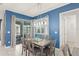 Well-lit dining area features a modern chandelier, blue accent wall, and sliding door to a screened-in patio at 2009 Tropical Palms Cir, Kissimmee, FL 34747