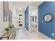Bright entryway with white tile flooring, blue accent wall, and view into a bedroom at 2009 Tropical Palms Cir, Kissimmee, FL 34747