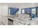 Open floor plan with a modern kitchen, granite countertops, and living area with a blue accent wall and plenty of seating at 2009 Tropical Palms Cir, Kissimmee, FL 34747