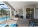 Covered patio area featuring a barbecue grill and comfortable seating for outdoor relaxation by the pool at 2009 Tropical Palms Cir, Kissimmee, FL 34747