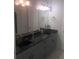 Stylish bathroom with dual sinks, dark countertops, and modern fixtures at 2300 Painter Ln, Kissimmee, FL 34741