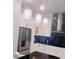 Bright kitchen with stainless steel appliances, white cabinets, black countertops and elegant pendant lights at 2300 Painter Ln, Kissimmee, FL 34741