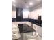 Bright kitchen showcases a black marble island with white cabinets and bar stool seating at 2300 Painter Ln, Kissimmee, FL 34741