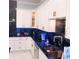 Stunning kitchen with black marble countertop, white cabinets, and stainless steel appliances at 2300 Painter Ln, Kissimmee, FL 34741
