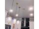 Stylish crystal pendant lights illuminating a kitchen with white cabinets and a stainless steel range hood at 2300 Painter Ln, Kissimmee, FL 34741