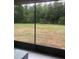 Screened-in patio featuring a tranquil view of the spacious yard and surrounding greenery at 2300 Painter Ln, Kissimmee, FL 34741