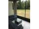 Relaxing screened patio with cozy seating area and a view of the expansive lawn and wooded area at 2300 Painter Ln, Kissimmee, FL 34741