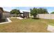 Expansive backyard with a lounging and dining area under a pergola, fire pit, and green space at 2751 Matera Dr, St Cloud, FL 34771