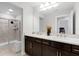 This bathroom features a dual sink vanity with bronze fixtures, a large mirror, and a glass-enclosed shower at 2751 Matera Dr, St Cloud, FL 34771