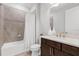 Bathroom featuring a shower-tub combo with tiled walls and a vanity with a dark wood cabinet at 2751 Matera Dr, St Cloud, FL 34771