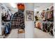 This large walk-in closet features ample storage with organized shelves, hanging rods, and visible clothing at 2751 Matera Dr, St Cloud, FL 34771
