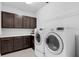 Laundry room with dark brown cabinets, countertop space and white washer and dryer at 2751 Matera Dr, St Cloud, FL 34771