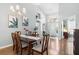 A dining room with a chandelier has a spacious table and multiple art pieces at 3016 Samosa Hill Cir, Clermont, FL 34714