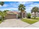 Charming single-story home with a two-car garage, manicured lawn, and lush tropical landscaping for curb appeal at 3016 Samosa Hill Cir, Clermont, FL 34714