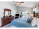 Spacious main bedroom featuring comfortable bedding, wood floors, and abundant natural light at 3016 Samosa Hill Cir, Clermont, FL 34714