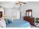 Relaxing main bedroom with blue bedding, ceiling fan, and dark wood dresser at 3016 Samosa Hill Cir, Clermont, FL 34714