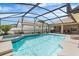 Sparkling screened-in pool and spa with lush landscaping, lounge chairs, and outdoor seating under a bright blue sky at 3016 Samosa Hill Cir, Clermont, FL 34714