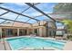 Backyard oasis featuring a sparkling screened-in pool, lounge chairs, and covered patio for relaxation and entertainment at 3016 Samosa Hill Cir, Clermont, FL 34714