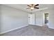 Bedroom featuring ceiling fan, gray carpet and trim, and bathroom entrance at 4126 Sw 132Nd Ln, Ocala, FL 34473