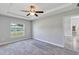 Bedroom featuring ceiling fan, gray carpet and trim, and large window at 4126 Sw 132Nd Ln, Ocala, FL 34473