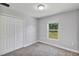 A bright bedroom features neutral walls, plush carpet, a window with a view, and a double-door closet at 4126 Sw 132Nd Ln, Ocala, FL 34473