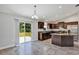Modern kitchen with dark cabinetry, granite counters, stainless steel appliances, and access to the backyard at 4126 Sw 132Nd Ln, Ocala, FL 34473