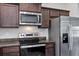 A closer view of a kitchen featuring stainless steel appliances and dark wood cabinetry at 4126 Sw 132Nd Ln, Ocala, FL 34473