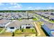 Expansive aerial view of a residential community featuring well-maintained homes and landscaping under a clear blue sky at 4485 Renly Ln, Clermont, FL 34711