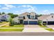 Striking two-story home showcasing a three-car garage, elegant stonework, and beautifully arched windows and a manicured lawn at 4485 Renly Ln, Clermont, FL 34711