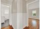 Hallway with hardwood floors, traditional wainscotting, and doorways leading to the bathroom and bedroom at 508 10Th St, St Cloud, FL 34769