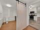 Charming kitchen with stainless steel appliances, white cabinets, and a rustic sliding barn door entrance to the bathroom at 508 10Th St, St Cloud, FL 34769