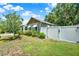 Side yard with white fence offering privacy, lush green lawn, and attractive landscaping at 508 10Th St, St Cloud, FL 34769