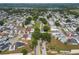 This aerial view showcases a neighborhood with mature trees and various styles of single-Gathering homes near a lake at 50989 Highway 27 # 371, Davenport, FL 33897