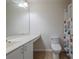Bathroom with a white vanity, toilet, mirror, and shower with a decorative curtain at 50989 Highway 27 # 371, Davenport, FL 33897