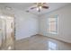 Inviting bedroom featuring tiled flooring, ceiling fan, double-door closet and window with a view at 50989 Highway 27 # 371, Davenport, FL 33897