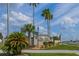 A welcoming sign for Bass Lake community featuring well-maintained landscaping and palm trees against a partly cloudy sky at 50989 Highway 27 # 371, Davenport, FL 33897