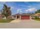 Charming single-story home features a well-maintained lawn and a striking red two-car garage door at 50989 Highway 27 # 371, Davenport, FL 33897