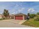 Detached, side-entry two-car garage with red doors and well-maintained landscaping on a sunny day at 50989 Highway 27 # 371, Davenport, FL 33897