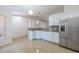 Open kitchen featuring tile floors, white cabinetry, stainless steel appliances, and granite countertops at 50989 Highway 27 # 371, Davenport, FL 33897