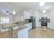 Bright kitchen with granite countertops, stainless steel appliances, white cabinets, and seamless flow to living spaces at 50989 Highway 27 # 371, Davenport, FL 33897