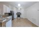 Well-lit kitchen showcases white cabinetry, stainless steel appliances, granite countertops, and tile flooring at 50989 Highway 27 # 371, Davenport, FL 33897
