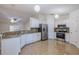 Spacious open kitchen with stainless steel appliances, white cabinets, granite countertops, and tile flooring at 50989 Highway 27 # 371, Davenport, FL 33897